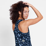 Woman wearing a navy floral dress with a white background