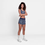 Woman wearing a navy athletic outfit with floral patterns on a white background
