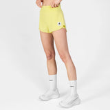 Person wearing yellow athletic shorts with a logo on a white background