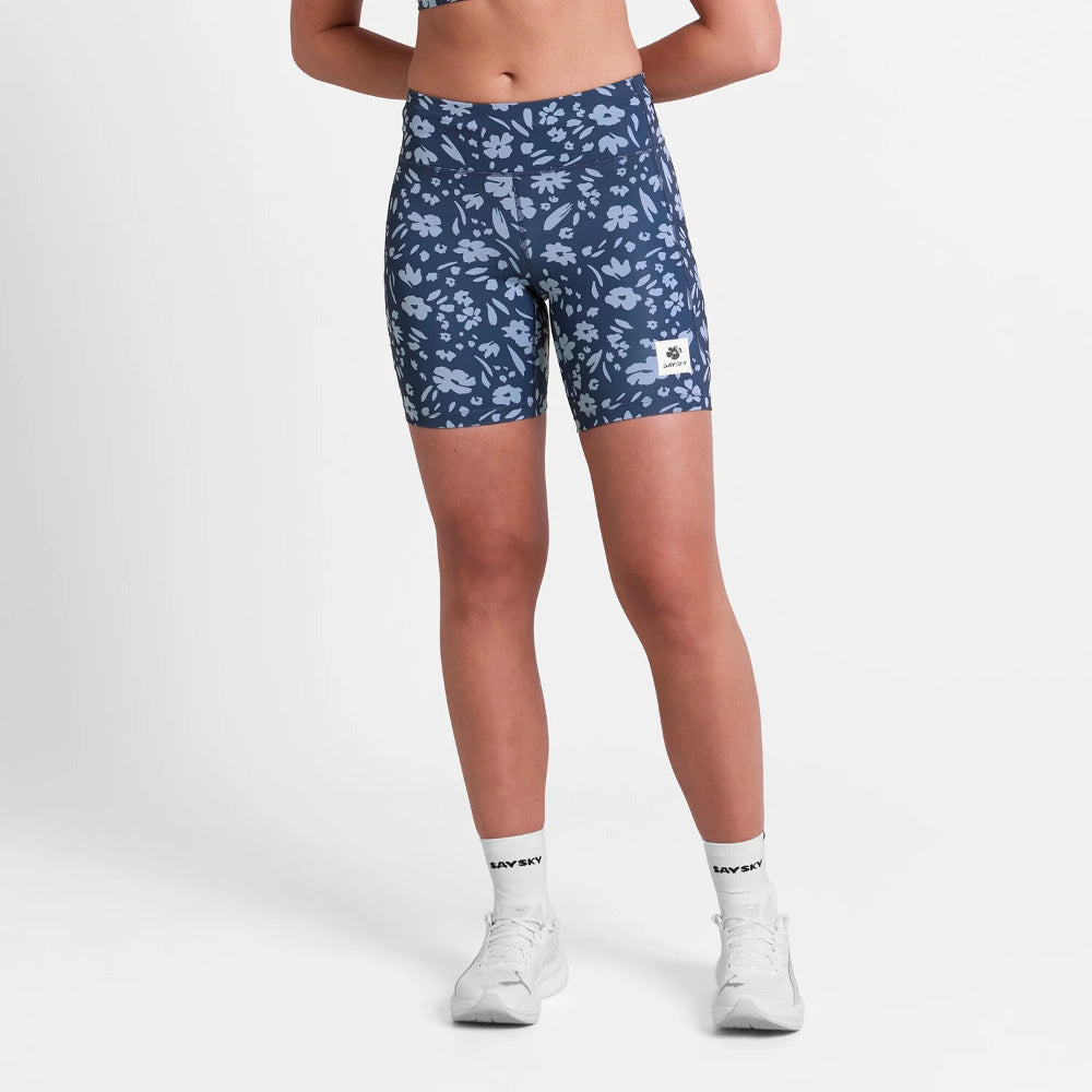 Person wearing blue floral shorts on a white background