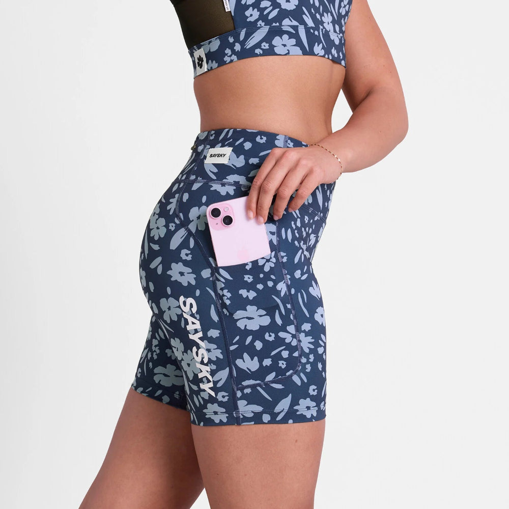 Person wearing navy floral shorts with a pink phone pocket on a white background