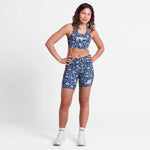 Woman wearing a blue floral sports outfit on a white background