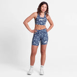Woman wearing a blue floral sports outfit on a white background