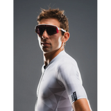 Man wearing a white cycling jersey with a dark background
