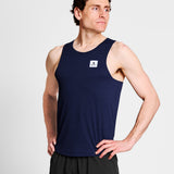 Man wearing a navy tank top with a logo on a light gray background