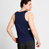 Man wearing a navy tank top with a small logo on a light gray background