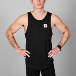 Man wearing a black tank top with a logo on a gray background