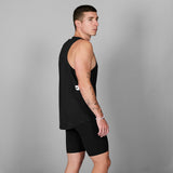 Man wearing a black sleeveless top and shorts on a gray background