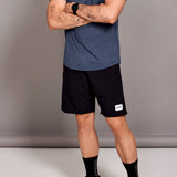 Person wearing a blue t-shirt and black shorts against a gray background