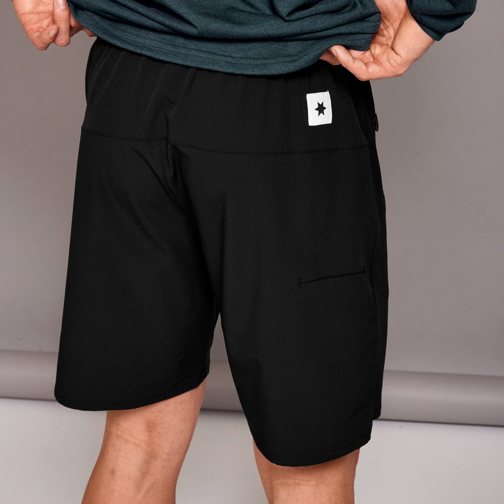 Black shorts with a brand logo on a neutral background