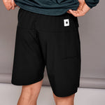 Black shorts with a brand logo on a neutral background