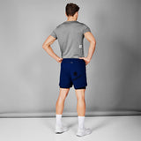 Man wearing a gray t-shirt and blue shorts on a gray background