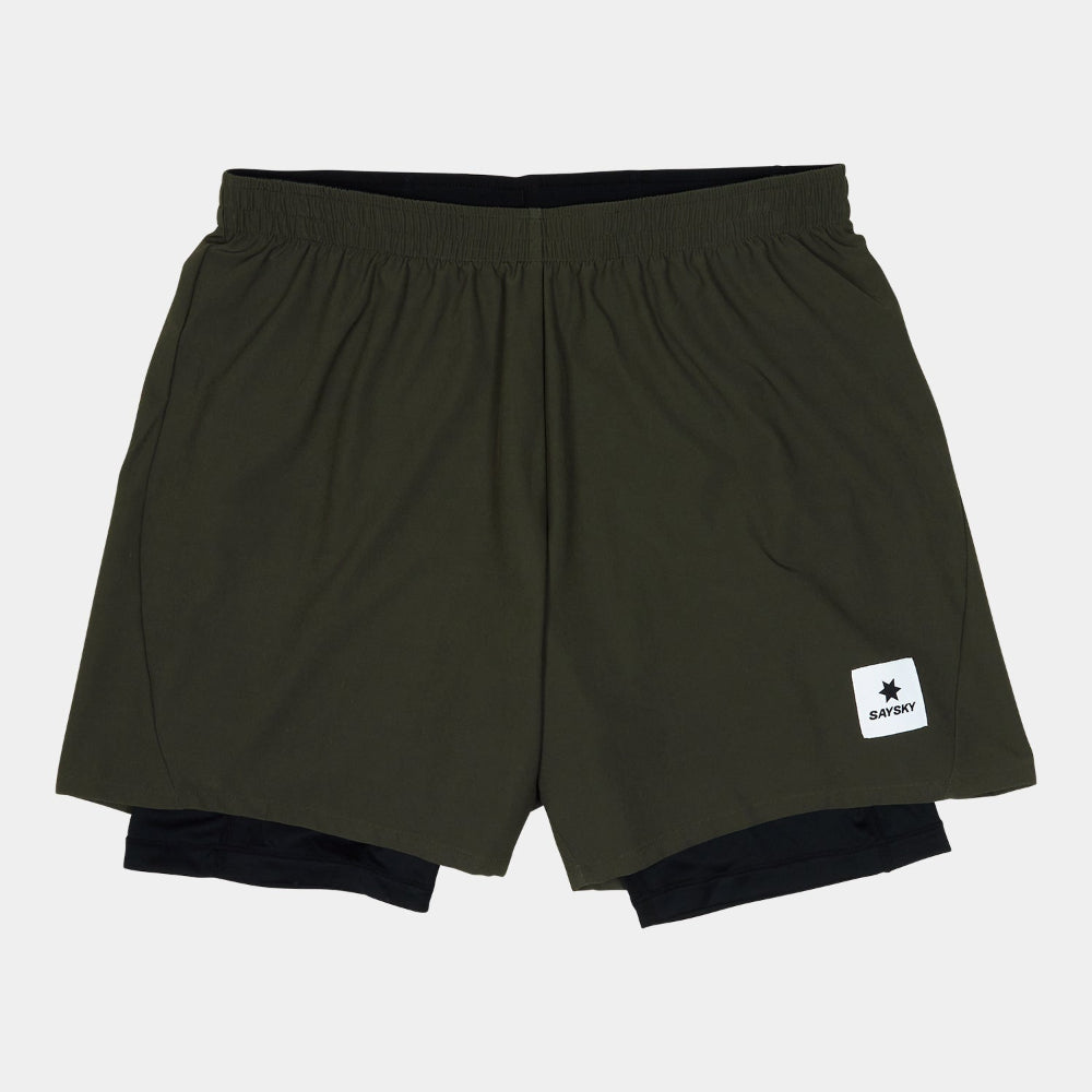 Green athletic shorts with a brand logo on a light gray background