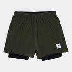 Green athletic shorts with a brand logo on a light gray background