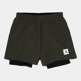 Green athletic shorts with a brand logo on a light gray background