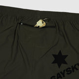 Black shorts with a gold zipper pull and star logo on a light gray background