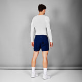 Person wearing a white long-sleeve shirt and blue shorts on a gray background