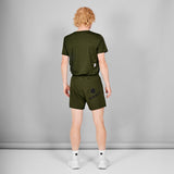 Person wearing a green t-shirt and shorts set on a gray background