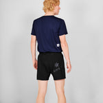 Person wearing a navy blue t-shirt and black shorts with 'SAYS' branding on a gray background