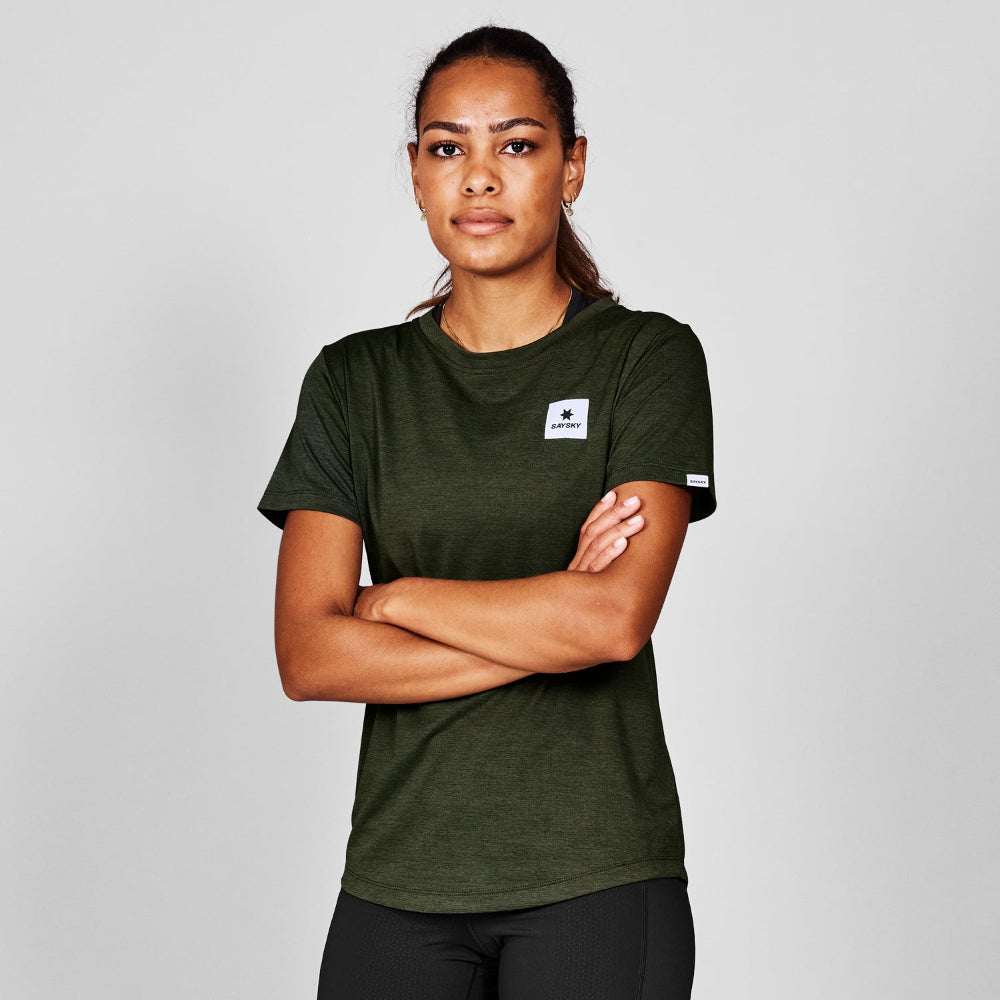 Person wearing a green t-shirt with a logo on a gray background