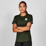 Person wearing a green t-shirt with a logo on a gray background