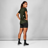 Person wearing a green athletic shirt and black shorts on a gray background