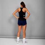 Person wearing a black tank top and blue shorts on a gray background