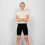 Person wearing a white t-shirt and black shorts on a plain background