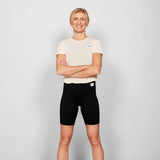 Person wearing a white t-shirt and black shorts on a plain background